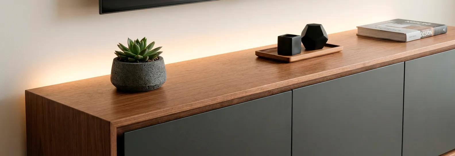 Mueble de TV flotante moderno color madera natural y cajones gris oscuro mate, decorado con planta y libro