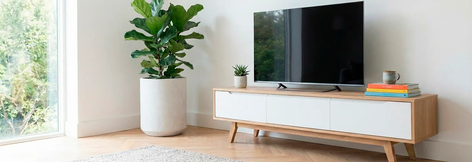 Mueble de TV bajo estilo nórdico con cajones blancos y estructura en madera clara en sala moderna iluminada